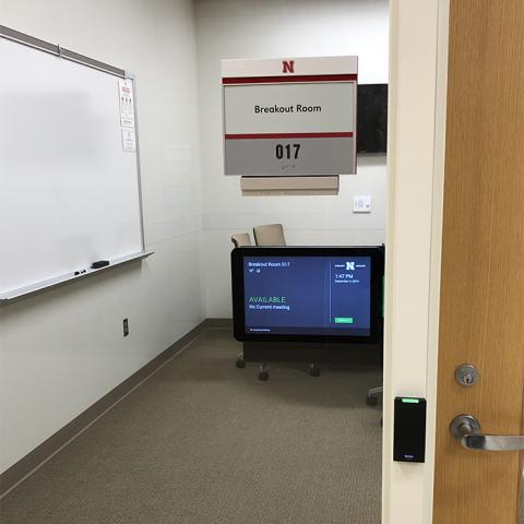 Front side of room schedule sign mounted on glass
